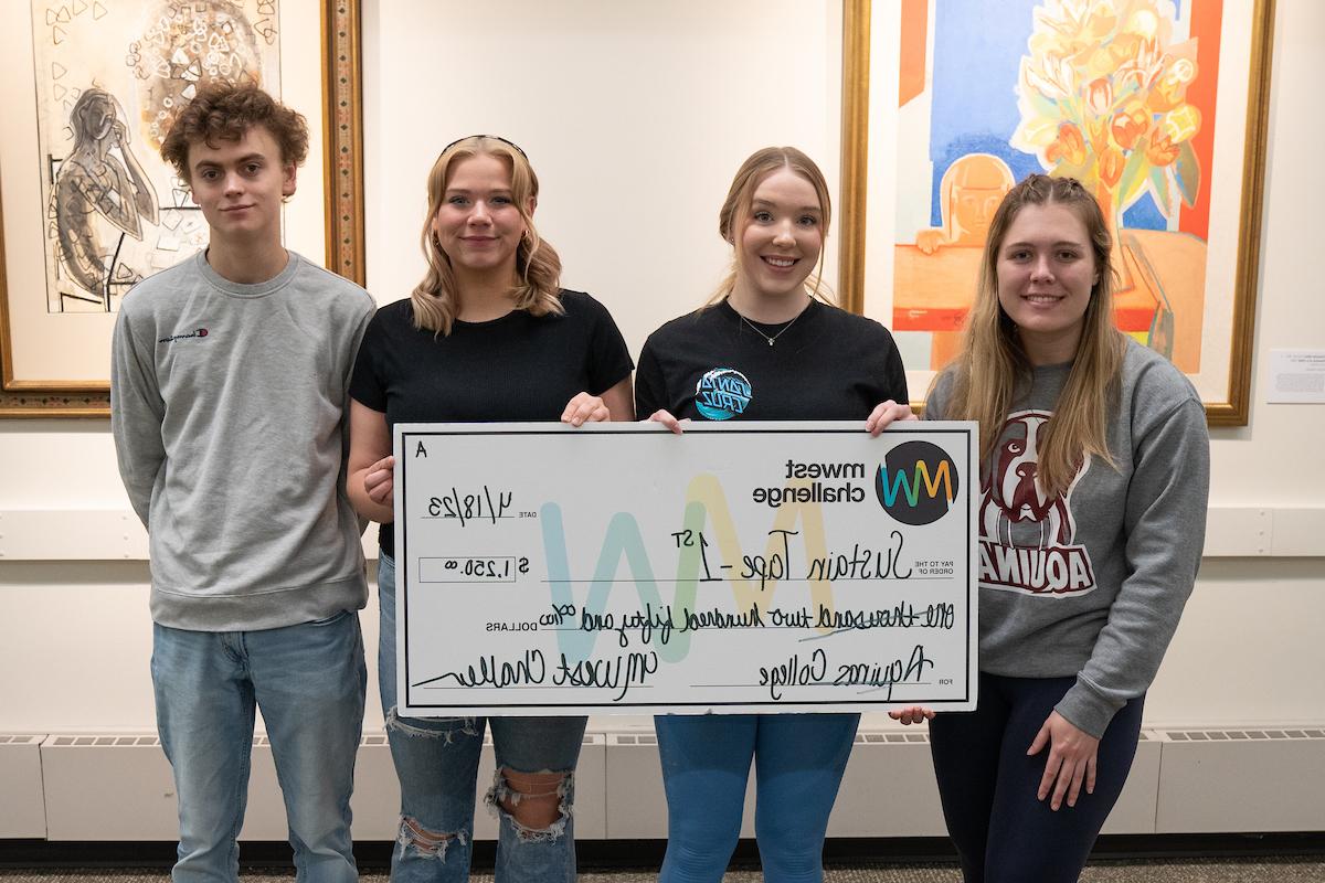 Four students holding an oversized check for SustainTape